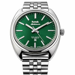 May include: A silver-toned wristwatch with a green face. The watch features the text "hmt Kohinoor" and "PARA SHOCK 17 JEWELS". The watch has a silver band and a date display at the bottom of the face.