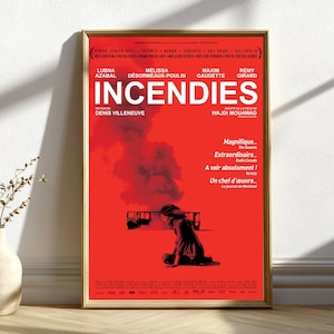 Könnte beinhalten: Ein gerahmtes Filmplakat für "Incendies" in einem goldenen Rahmen. Das Plakat ist überwiegend rot mit weißem Text und zeigt den Titel und die Credits des Films. Eine Silhouette einer Person sitzt vor einer dunklen Wolke. Das Plakat enthält Filmbewertungen.