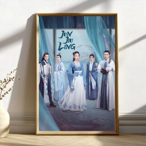 May include: A framed poster featuring five individuals in traditional Asian attire. The poster has a gold frame and displays the title "Jun Jiu Ling" in stylized lettering. The characters are dressed in shades of blue and white, with ornate details.