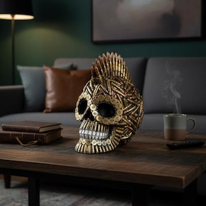 以下が含まれることがあります： 真鍮色の薬莢で作られた装飾的な頭蓋骨の彫刻。 頭蓋骨は薬莢のモヒカンヘアと詳細な顎のラインを持っています。 リビングルームの木製コーヒーテーブルの上にあります。