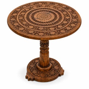 May include: A round wooden side table featuring intricate hand-carved floral patterns across the tabletop, central pedestal, and circular base. The medium-brown wood displays a natural grain texture with detailed relief carvings of flowers and vines.
