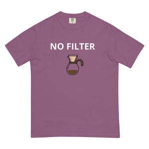 Puede incluir: Camiseta malva con la frase "NO FILTER" en blanco sobre una ilustración de dibujos animados de un dispositivo de café. La cafetera es marrón y beige, con una jarra de vidrio llena de líquido marrón.