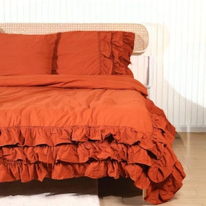 Puede incluir: Una taza de cerámica blanca con un asa negra y el texto "But First, Coffee" en negro, con una fuente de estilo manuscrito. La taza está sobre una superficie blanca.