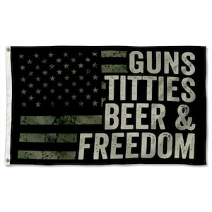 Puede incluir: Bandera negra con un diseño desgastado de la bandera estadounidense y las palabras "GUNS, TITTIES, BEER & FREEDOM" en letras blancas y en negrita. La bandera tiene ojales para colgar.