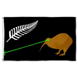 May include: Black flag with a brown kiwi bird and a green laser beam. A white fern leaf is in the upper left corner. The flag has eyelets for hanging. The design is a humorous take on a national symbol.
