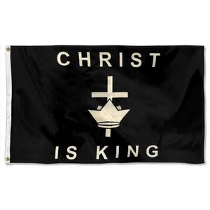 May include: Black flag featuring the words "CHRIST IS KING" in white, bold lettering. A white emblem of a crown and cross is centered between the words. The flag is designed for hanging, with grommets visible on the left edge.
