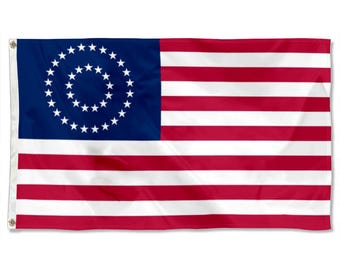 Peut inclure: Un drapeau rectangulaire avec un canton bleu orné d'une spirale d'étoiles blanches. Le drapeau présente des rayures horizontales rouges et blanches alternées. Des œillets sont visibles sur le côté gauche pour l'accrochage. Un symbole patriotique.