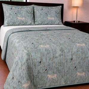 May include: A sage green quilted bedspread and two matching pillow shams featuring a repeating pattern of cheetahs, tropical palm trees, and various birds. The bedding set has a soft, muted color palette with detailed illustrations across the fabric.
