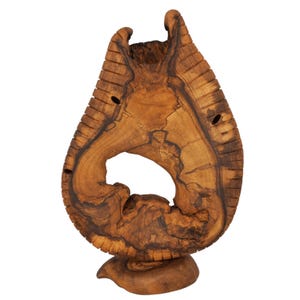 May include: A handcrafted, teardrop-shaped wooden sculpture with a natural, organic aesthetic. The sculpture features a large central opening and is supported by a rounded base. The wood grain is visible, showcasing the natural color variations of the material.
