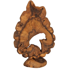 Puede incluir: Una escultura decorativa de madera con una forma natural y orgánica. La escultura está hecha de madera marrón claro con vetas marrones oscuras. Presenta una gran abertura irregular y se asienta sobre una pequeña base redondeada. La madera tiene una superficie texturizada.