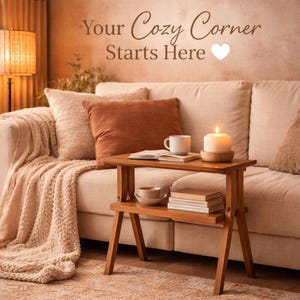 May include: A cozy living room scene with a cream-colored sofa, throw pillows, and a wooden side table. The table holds a lit candle, a mug, and books. A knitted throw blanket and the text "Your Cozy Corner Starts Here" complete the warm, inviting atmosphere.