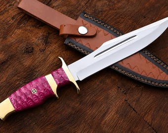 Cuchillo artesanal de hoja fija con mango de resina rosa y funda de cuero.