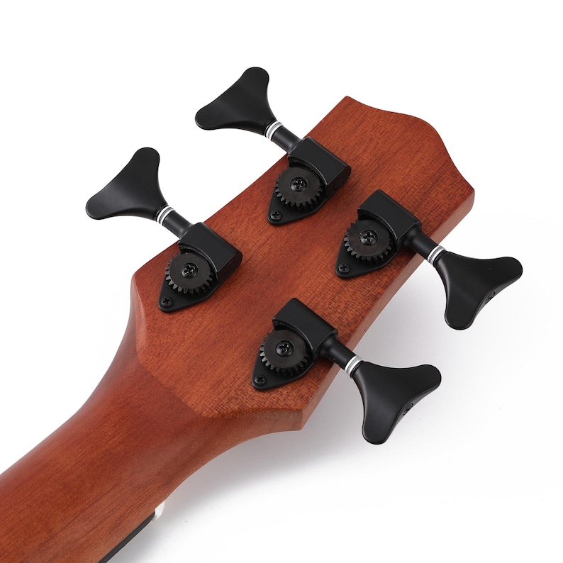 May include: Close-up of the headstock of a ukulele, showcasing four black tuning pegs. The pegs are arranged in a symmetrical pattern on the wooden headstock, which has a warm, reddish-brown hue. The design suggests a musical instrument.
