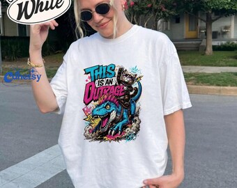 This Is an Outrage Shirt, Cat Riding Dinosaur Tee, Funny Graphic T-Shirt, Comfort Colors Top, Gift for Cat Lovers, T-Rex and Cat Graphic Tee