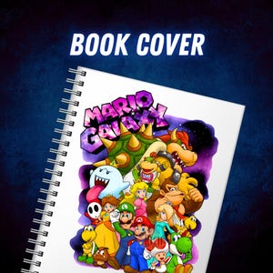 Puede incluir: Un cuaderno de espiral con una colorida ilustraci&oacute;n de personajes del videojuego Mario Galaxy. La portada muestra el texto "BOOK COVER" en la parte superior y el t&iacute;tulo del juego en una fuente con tem&aacute;tica de galaxia.