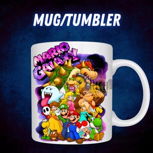 Puede incluir: Taza de cer&aacute;mica blanca con un gr&aacute;fico colorido de personajes del videojuego Mario Galaxy. La taza tiene un asa grande y el texto "MARIO GALAXY" se muestra de forma destacada. El fondo es azul oscuro con un dise&ntilde;o de galaxia p&uacute;rpura.