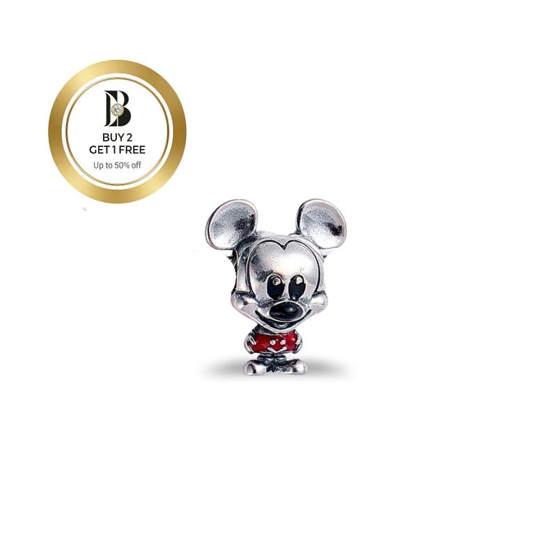 May include: A silver-colored Mickey Mouse charm with a red shirt and black eyes and nose. The charm has a classic Mickey Mouse design and is likely made of metal. The charm is on a white background.