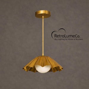 Könnte beinhalten: Goldfarbene Pendelleuchte mit einem gewellten Schirm und einer weißen Kugel in der Mitte. Die Leuchte ist an einer passenden goldenen Deckenhalterung aufgehängt. Der Text "RetroLumeCo. Buy Lighting for Home or Business" ist sichtbar.