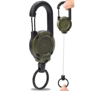 May include: Two olive green and black retractable keychains with carabiner clips. One keychain is fully extended, showing the steel wire and key ring. The other keychain is closed. The keychains have a rugged, tactical design.