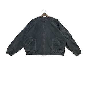 May include: A charcoal gray zip-up jacket featuring a round neckline, long sleeves with elastic cuffs, and a ribbed elastic hem. The garment includes two large front pockets with diagonal openings and a small utility pocket on the left sleeve.