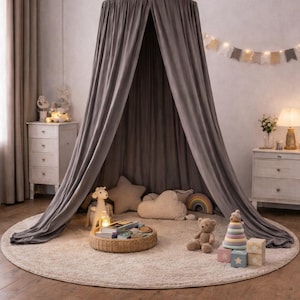 May include: A gray canopy bed with draped fabric, creating a cozy play area. The scene includes a round rug, stuffed animals, pillows, and a woven tray with books. A garland of flags and a lamp add to the decor.