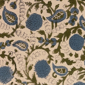 May include: Close-up of a fabric with a repeating floral pattern. The design features blue, green, and white elements. Blue flowers and paisley shapes are interspersed with green vines and leaves on a cream background.