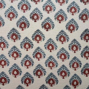 May include: Cream-colored fabric with a repeating pattern of stylized leaf shapes. Each leaf is composed of a dark teal outline with a burgundy center, creating a symmetrical design. The fabric has a textured appearance.