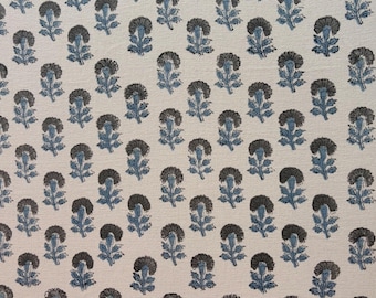 May include: Cream-colored fabric with a repeating pattern of stylized flowers. The flowers have dark gray centers and blue-gray leaves and stems. The design is evenly spaced across the fabric.