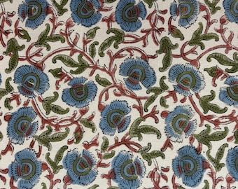 May include: Floral fabric with a repeating pattern of blue flowers, green leaves, and red vines on a cream background. The design is a block print style, with a vintage or bohemian aesthetic.