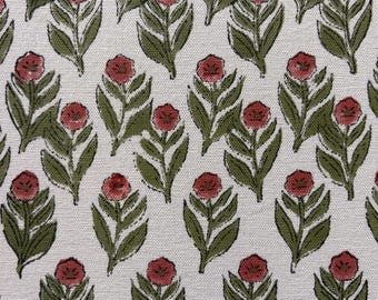May include: A repeating pattern of stylized red roses and green leaves on a cream-colored background. The floral design is block-printed, creating a textured appearance. The fabric is likely cotton or linen.