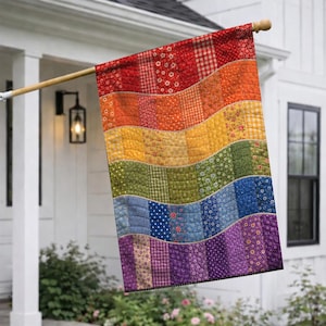 May include: A rectangular garden flag featuring a quilted design with wavy horizontal bands in a rainbow color sequence. Each band consists of vertical fabric strips with various floral, gingham, and polka dot patterns in red, orange, yellow, green, blue, and purple.