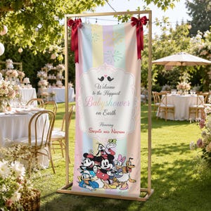 May include: A vertical banner on a gold metal stand featuring pastel vertical stripes, red bows at the top, and Disney characters at the bottom. The text reads: Welcome to the Happiest Babyshower on Earth Honoring Sophia and Nathan.