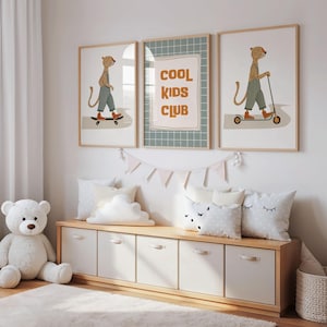 Puede incluir: Tres cuadros de pared enmarcados que muestran un leopardo en monopat&iacute;n, el texto COOL KIDS CLUB sobre un fondo de cuadr&iacute;cula verde y un leopardo en patinete. Los cuadros se exhiben sobre un banco de almacenamiento de madera con cinco cajones.