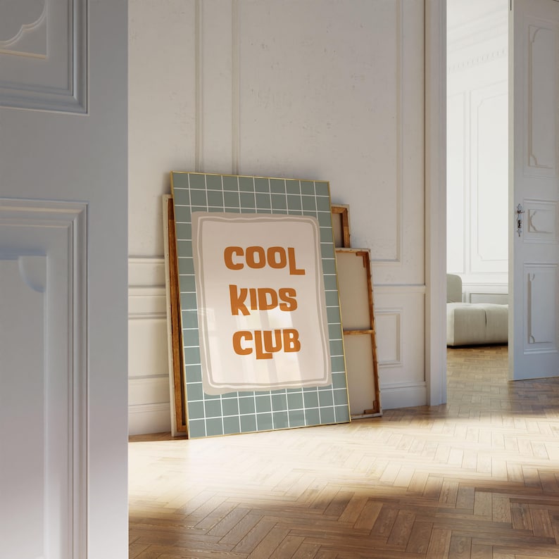Puede incluir: Un cuadro decorativo rectangular con un fondo de patr&oacute;n de cuadr&iacute;cula en color verde salvia y una forma rectangular central de color crema. El texto COOL KIDS CLUB est&aacute; impreso en una fuente sans-serif redondeada, negrita y naranja.