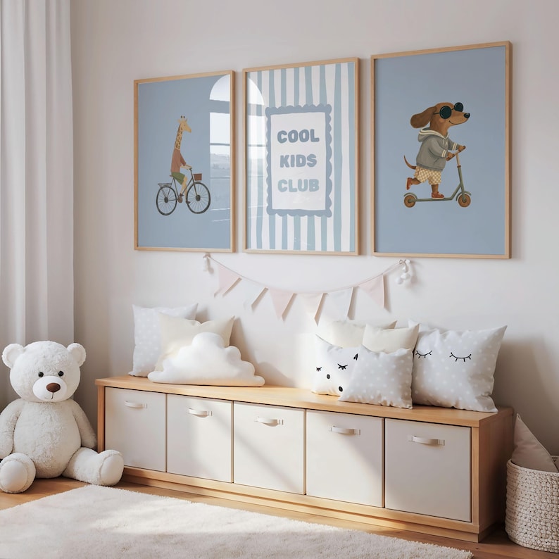 Puede incluir: Tres l&aacute;minas decorativas enmarcadas con fondo azul claro. La de la izquierda muestra una jirafa en bicicleta, la central contiene el texto COOL KIDS CLUB en un marco azul, y la de la derecha representa a un perro con gafas de sol en un patinete.