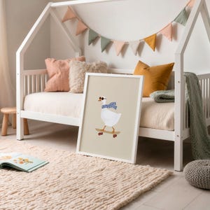 Puede incluir: Una l&aacute;mina de arte enmarcada que muestra a un ganso blanco con gafas de sol redondas y una bufanda de cuadros azules y blancos sobre un monopat&iacute;n beige. La ilustraci&oacute;n se presenta sobre un fondo beige claro liso dentro de un marco blanco.
