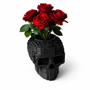 May include: A black, geometric skull-shaped vase holding a bouquet of vibrant red roses. The vase is constructed from small, square blocks, giving it a pixelated appearance. The roses have green leaves.