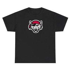 Può includere: T-shirt nero con grafica di una testa di lupo con bandana rossa e benda sull'occhio. Il lupo ha un muso grigio e bianco con un occhio giallo. La grafica è bordata di bianco.