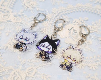 May include: Three anime-style keychains featuring cartoon characters with cat-like features. Each keychain has a silver-colored ring and clasp. The characters are dressed in black and gold outfits, with different colored hair and eyes.