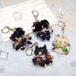 Peut inclure: Quatre porte-clés en acrylique avec des personnages de style anime, chacun avec un porte-clés argenté. Les personnages ont les cheveux noirs et portent différentes tenues, dont un chapeau de sorcière et un haut-de-forme. Les porte-clés sont sur une surface bleu clair.