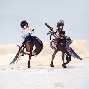 Op de afbeelding: Twee acryl anime figuren van vrouwelijke personages. Eén draagt een wit overhemd en een blauwe rok, de ander een zwart dienstmeisjesoutfit. Beide houden grote wapens met ingewikkelde ontwerpen vast. De figuren staan op heldere bases.