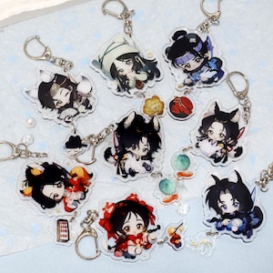 May include: A collection of clear acrylic keychains featuring anime-style character designs. The keychains have silver metal hardware and depict various characters in colorful outfits. Some characters have animal ears and accessories.