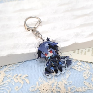 May include: A clear acrylic keychain featuring a chibi anime character with blue hair and red eyes. The character is wearing a dark outfit with blue accents. The keychain has a silver metal clasp.
