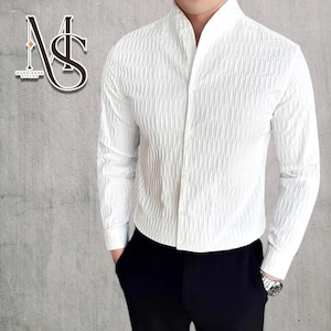 May include: White textured long-sleeved shirt with a mandarin collar and button-down front. The shirt features a vertical ribbed pattern. The logo "MS" is in the upper left corner. The shirt is paired with black trousers.
