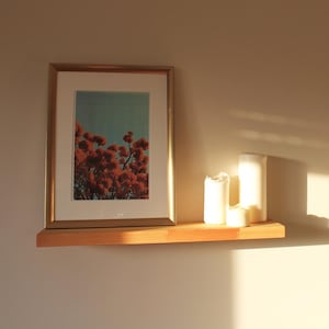 May include: A white ceramic mug with a black handle and the text "But First, Coffee" in a handwritten style. The mug is on a white surface. The mug is approximately 10 cm tall.