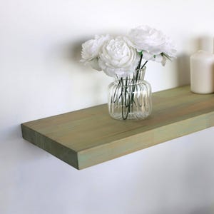 May include: A set of three ceramic mugs with a speckled, matte finish in cream, light grey, and dark grey. Each mug has a simple, minimalist design, suitable for coffee or tea.