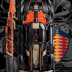 Könnte beinhalten: Eine Draufsicht auf ein schwarzes, beiges und oranges LEGO Technic Koenigsegg Jesko Modellauto. Das Fahrzeug weist komplexe mechanische Details, freiliegende Motorkomponenten und einen aerodynamischen Rahmen auf. Der Hintergrund zeigt stilisierte Grafiken.