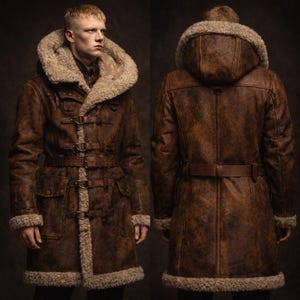 May include: A brown leather coat with a fur-lined hood and trim. The coat features a belt at the waist and multiple buckle closures. The image shows both the front and back of the coat.