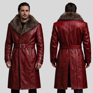 May include: A burgundy leather coat with a fur collar and a belt. The long coat has a classic design with a notched collar and a belt at the waist. The coat is shown from the front and back.