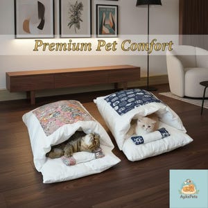 Puede incluir: Dos camas blancas para mascotas con detalles estampados. Una cama tiene un diseño rosa y gris, la otra un patrón azul y blanco. Dos gatos están acurrucados dentro de las camas. El texto "Premium Pet Comfort" se muestra en la parte superior.